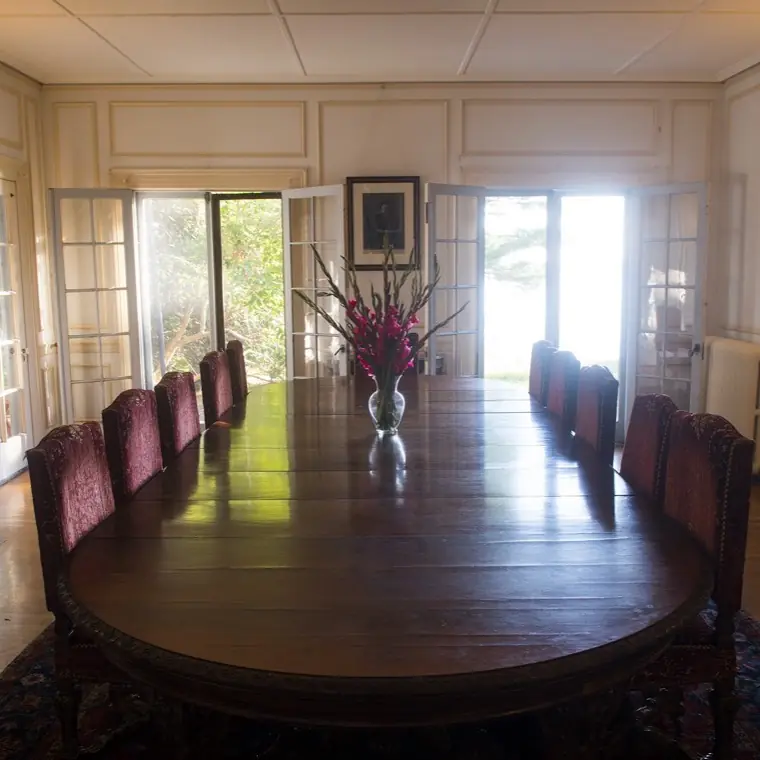 The dining room set for a meal, with tall windows looking out over Frenchman Bay